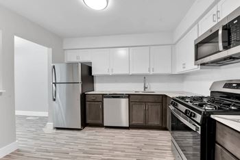 A kitchen with a refrigerator, dishwasher, and stove.